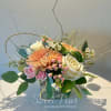 A delightful mix of salmon colored mums, cream roses, Peach Spray roses