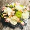 The combination of roses and carnations creates a beautiful contrast between the