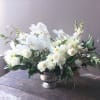 Elegant blooms of whites and green foliages artfully gathered in a vase.