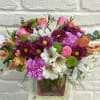 This colorful arrangement consists of roses, alstroemerias, tulips and green buttons. 