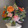 A beautiful, one-of-a-kind floral arrangement with fresh seasonal flowers in a vase.
