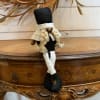 This medium size gnome has dangling legs, two long braids and a