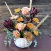 A white ceramic pumpkin filled with lovely fall colors. For a centerpiece