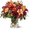 A profusion of fall-toned flowers including Asiatic lilies, roses, miniature callas, hydrangea