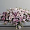 This casket spray features many shades of pinks. It features gerbers daisies
