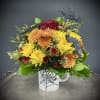 A whimsical floral arrangement bursts from a keepsake (and reusable) coffee mug