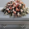 This casket spray features shades of peaches with roses, asltro and much