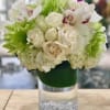Mixed floral arrangement with soft white color hue of white roses, spray