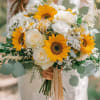 This handtied bouquet features sunflowers and white roses. Perfect for anyones special