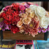 A stylized and modern floral arrangement in a muted tan hue, hints