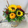 An assortment of fall flowers arranged in a vase or container. Every