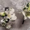 White Dendrobium orchids make up this wrist corsage and boutonniere ensemble. Please