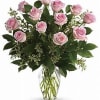 Dozen pink roses in a clear vase with beautiful greens. This is