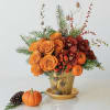 Pumpkin Joy is a cheerful autumn arrangement featuring bright orange roses, playful