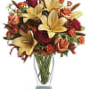 Orange, dark orange and red roses blend with orange asiatic lilies, green