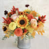 Cheerful seasonal blooms, autumn leaves, and delicate accents arranged in a galvanized