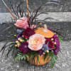 This beautiful arrangement is in a ceramic pumpkin with  peach roses