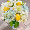 Hydrangeas, tulips, seasonal white flowers and lemons in a French country crock