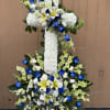 A beautiful standing floral cross made with pure white flowers accented by
