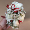 A classic white corsage with some ribbons, this wrist arrangement looks good