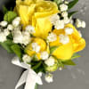 Cheerful yellow roses accented with soft baby&rsquo;s breath and fresh greenery, tied