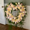 This fresh heart shaped wreath arrangement has an elegant garden style look