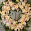 This fresh heart shaped wreath arrangement has an elegant garden style look