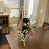 A bud vase filled with a silk black rose and filled with