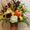 A large galvanized pumpkin patch cylinder filled with a beautiful fall arrangement