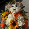 This arrangement features a playful floral puppy crafted from white carnations, accented