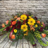 This vibrant casket spray offers a heartfelt expression of love and remembrance