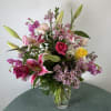 A sumptuous vase arrangement of knockout garden flowers featuring stargazer lilies.