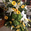 A lovely standing spray of yellow and white seasonal blooms. Includes stand.