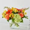 Clear vase with hydrangea, snapdragons, orange gerbera daisies and fillers. 