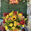 In a ceramic pumpkin with red sparkle roses and fall flowers