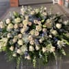 An abundant high-end design of lush roses, delphinium and Casa Blanca Lilies