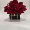 A stylish paper purse overflowing with fresh, vibrant roses, accented by a