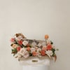 An elegant floral gift box featuring nude and peach roses with seasonal
