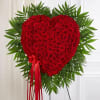 Heart-shaped arrangement of over 100 red roses accented with soft, lush greenery.
