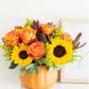 This charming floral arrangement is artfully presented in a faux pumpkin container