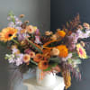 A beautiful one-of-a-kind floral arrangement of fresh seasonal flowers in a vase.