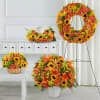 The Autumn Tribute Sympathy Bundle celebrates life with sunflowers, orange roses, lilies