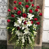 Pure white lilies and dendrobium orchids mingle with red roses, white asiatic