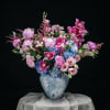 A luxurious designer arrangement bursting with seasonal romance. The &ldquo;Enchanted Symphony&rdquo; combines