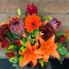A beautiful fall arrangement with orange lilies, gerbera daisies, proteas, solidago, alstromeria