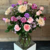 A lovely arrangement of soft colored blooms including roses, carnations, and cremones