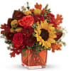 Sunny sunflowers and radiant roses in a happy orange cube vase bring