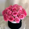 A medium round black velvet box with roses arranged in a dome