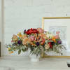 A lush and unique arrangement with berries, dried fruit, garden roses, muted