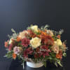 An inviting arrangement filled with blooms in spiced tones, perfect for setting
